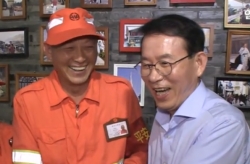 민병철회장은 환경미화원들에게 무료로 국수를 나눠주는 식당에서 지원봉사를 한 후 현지 미화원들과 담소를 나누며 활짝 웃고 있는 모습.