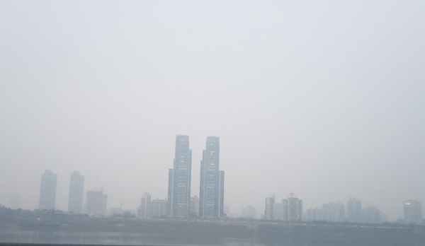 서울 올림픽대로에서 바라본 한강 건너의 주상복합빌딩이 미세먼지 안에서 고목처럼 서있는 것처럼 보인다.