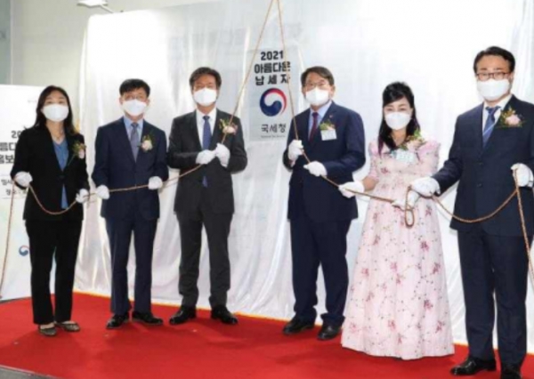「아름다운 납세자 홍보관」 제막식에서 가림막을 제거하는 모습.왼쪽부터 김영순 납세자보호관, 문희철 국세청 차장, 김대지 국세청장, 삼천포서울병원 이승연 대표, 장다리마늘약선 이옥자 대표, 정철우 징세법무국장/사진=국세청.