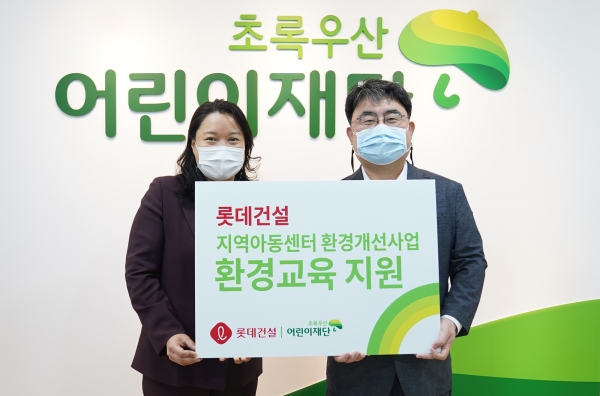 롯데건설 전략기획부문 한정호 상무(오른쪽)와 초록우산 어린이재단 최운정 본부장(왼쪽)이 기증판 전달식을 진행했다. 사진=롯데건설.