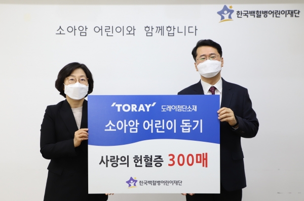 도레이첨단소재 김은주 상무(왼쪽)가 헌혈증 300매를 서선원 한국백혈병어린이재단 사무총장에게 전달하고 있다.