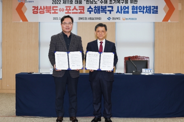 포스코가 경상북도와 힌남노 태풍피해 조기 수해복구 추진을 위해 협력한다. 포스코 김학동 부회장(사진 오른쪽)과 경상북도 김학홍 행정부지사가 6일 경북도청에서 협약체결 후 기념촬영을 하고 있다. 사진=포스코.<br>