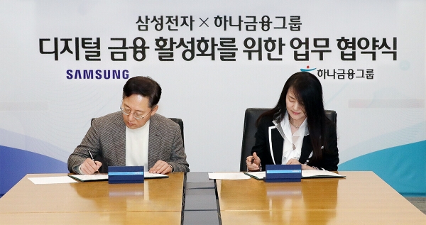 하나금융그룹은 지난 27일 명동사옥 본점에서 글로벌 초일류 기업 삼성전자와 디지털금융 활성화로 새로운 비즈니스 창출에 적극 협력하기 위한 전략적 파트너십을 체결했다고 밝혔다. 사진(박성호 하나금융그룹 부회장(왼쪽)과 한지니 삼성전자 부사장(오른쪽)이 협약서에 서명을 하고 있다.)=하나금융.