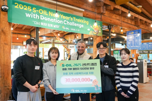 S-OIL 안와르 알 히즈아지 CEO(가운데)와 신입사원들이 17일 신년 트래킹으로 달성한 걸음 기부 챌린지 기념촬영을 하고 있다. 사진=에쓰오일.