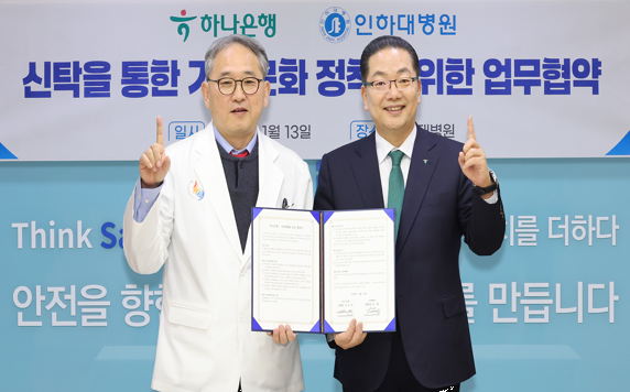 이날 협약식에 참석한 이호성 하나은행장(사진 오른쪽)이 이택 인하대병원장 겸 의료원장(사진 왼쪽)과 협약서를 들고 기념촬영을 하고 있다. 사진=하나은행.<br>
